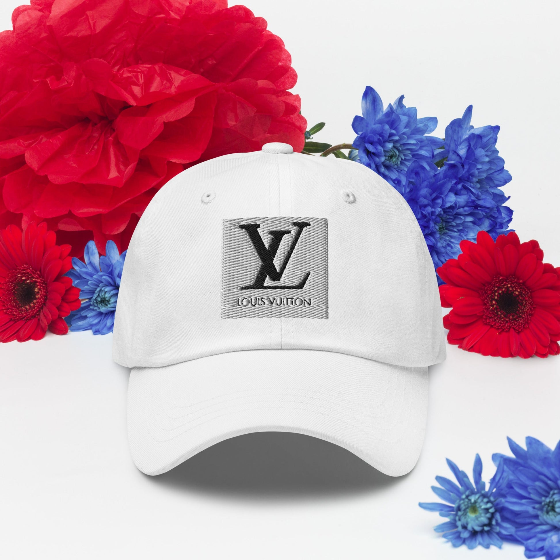 White dad hat with a curved visor and adjustable strap, surrounded by red and blue flowers.